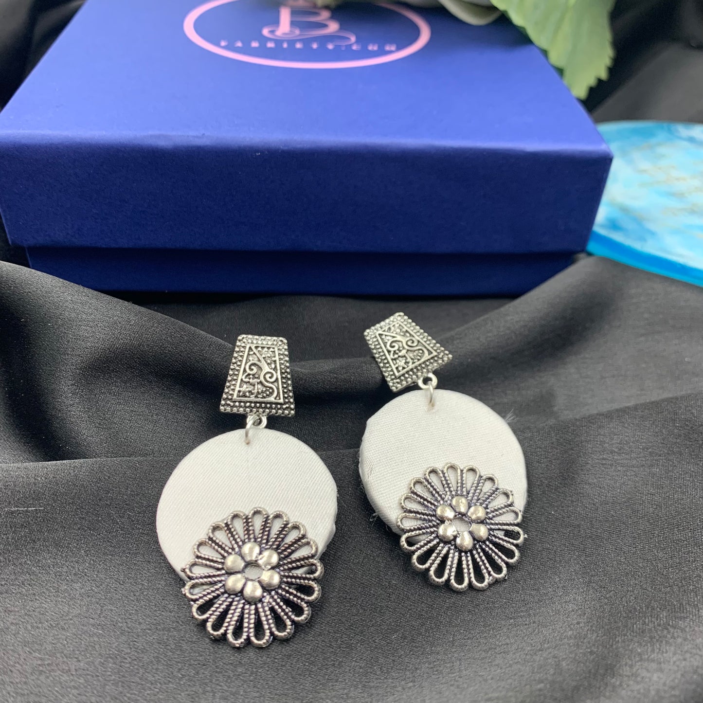 White Fabric Circular Earrings With Silver Charms