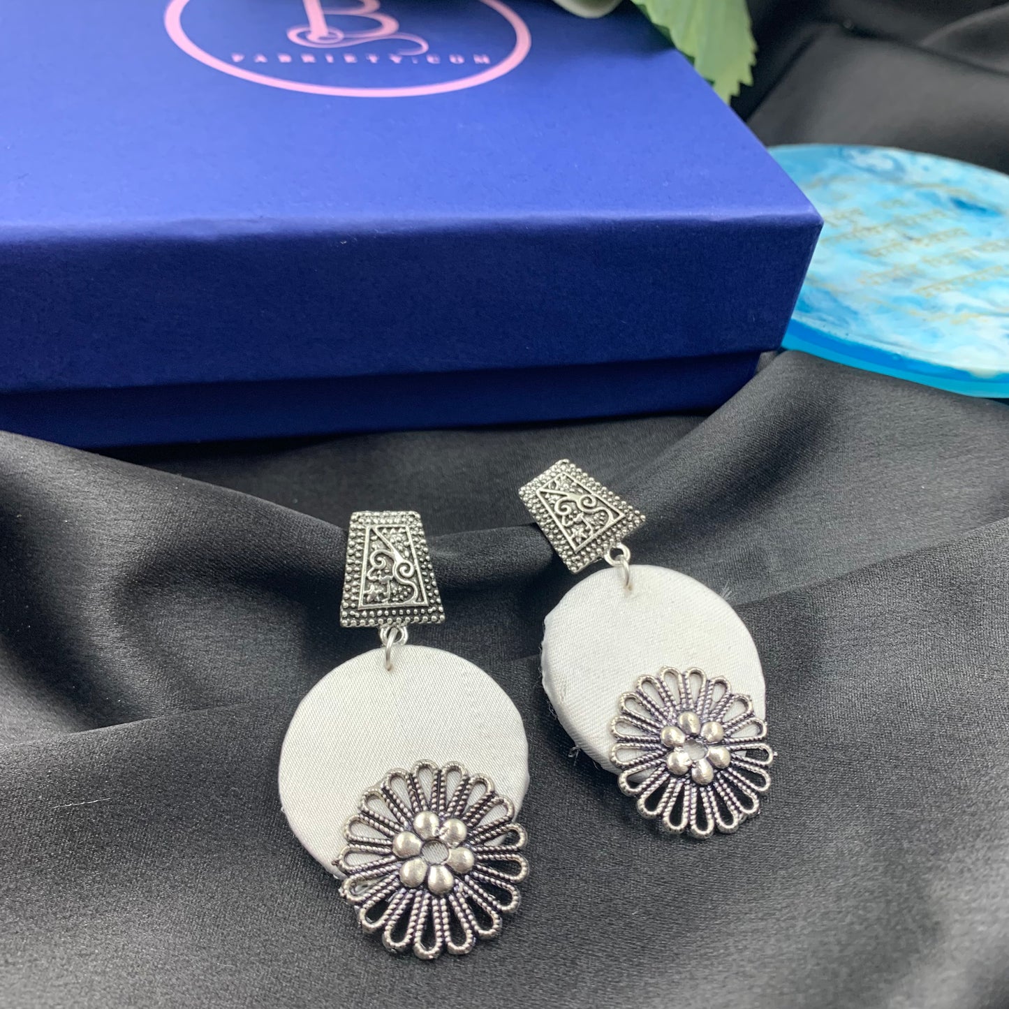 White Fabric Circular Earrings With Silver Charms